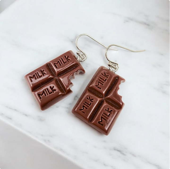 Add a touch of sweetness to your jewelry collection with these quirky and unique chocolate bar charm earrings! Perfect for candy lovers and those who enjoy fun accessories. These handmade earrings feature detailed chocolate bar charms, making them a playful addition to any outfit.